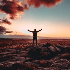 Man holding arms out standing on mountain