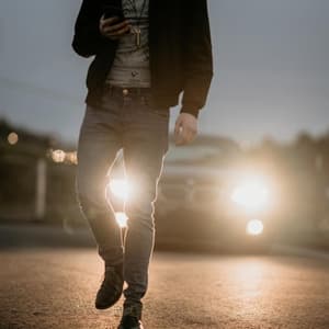 Man staring at phone near car