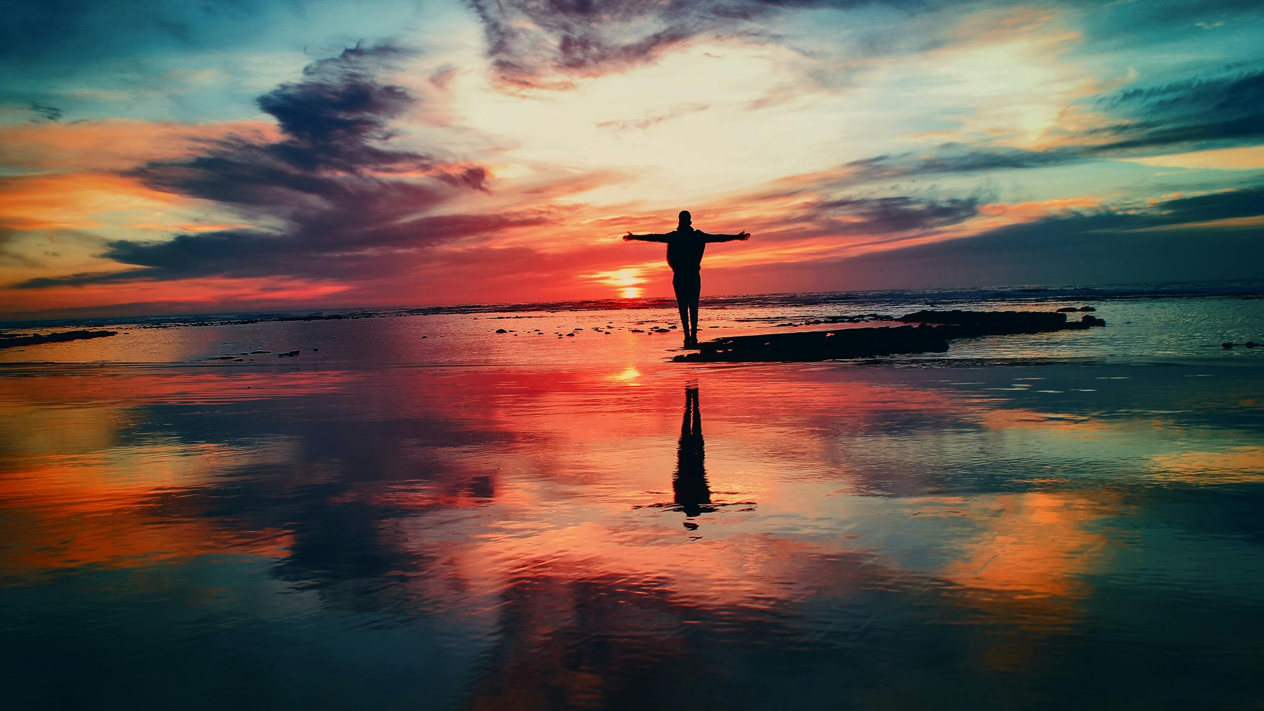 Man standing near ocean during sunset